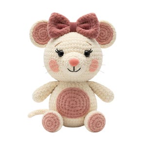 Könnte beinhalten: Ein handgefertigtes Häkelmaus-Spielzeug in Creme mit einer rosa Schleife, Ohren, Nase und Bauch. Das Spielzeug hat schwarze Augen, rosa Wangen und Schnurrhaare. Die Maus sitzt aufrecht, mit ausgestreckten Armen und Beinen.