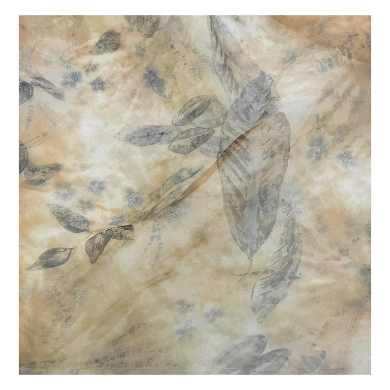 May include: A beige fabric with a light brown and gray leaf pattern. The fabric has a soft, flowing texture.