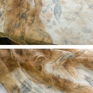 May include: A sheer fabric with a brown and white leaf pattern. The fabric is translucent and has a delicate texture.