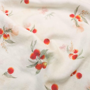 May include: Off-white fabric with a repeating pattern of red and orange berries, green leaves, and delicate pink flowers. The fabric has a soft, slightly wrinkled texture, suggesting a natural material like linen or cotton.