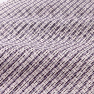 May include: Close-up of a fabric with a white and purple plaid pattern. The fabric is folded, showing the texture and diagonal lines of the weave. The pattern is a classic design, suitable for various sewing projects.