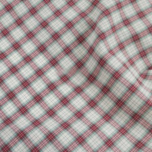 Op de afbeelding: Close-up van een stof met een ruitpatroon. Het patroon heeft een raster van elkaar kruisende lijnen in rood en lichtblauw over een witte achtergrond. De stof is licht gekreukt, wat suggereert dat hij zacht is.