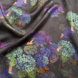 May include: Dark fabric with a floral pattern featuring blue, purple, and green hydrangea blooms. The fabric has a subtle sheen and a dark background, with hints of orange butterflies.
