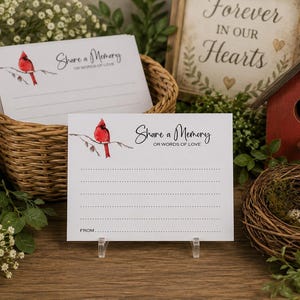 May include: A stack of white rectangular memory cards featuring a red cardinal bird illustration on a branch and the black printed text Share a Memory or words of love, with dotted lines for writing and a space labeled FROM at the bottom.