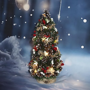 Può includere: Un albero di Natale decorativo fatto di pigne, adornato con bacche rosse, fiori bianchi e piccole luci. L'albero è legato con fiocchi di spago e poggia su una base di legno, creando un'atmosfera festosa.