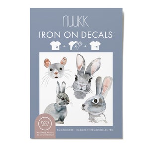 Peut inclure: Décalcomanies thermocollantes illustrant une souris et trois lapins peints à l'aquarelle. Les décalcomanies sont lavables à 60°C (140°F). Le texte "nuukk IRON ON DECALS" est en haut de l'image.