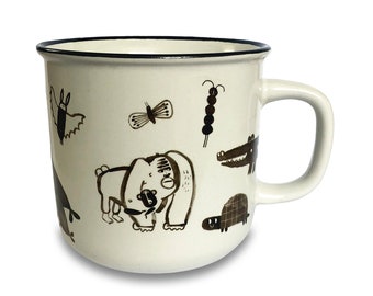 Può includere: Una tazza in ceramica bianca con un bordo e un manico neri. La tazza presenta un design fantasioso di animali e insetti in inchiostro nero, tra cui un orso, una farfalla, una tartaruga, un alligatore e un pipistrello.