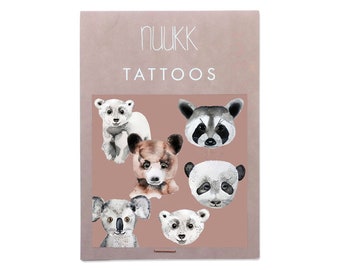 May include: A sheet of temporary tattoos featuring watercolor illustrations of animal faces. The animals include a polar bear, raccoon, panda, koala, and brown bear. The tattoos are on a pink background with the text "nuukk tattoos" at the top.