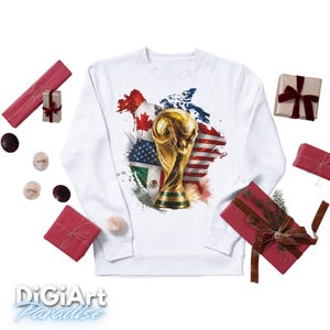 May include: White sweatshirt featuring a gold trophy and flags of the United States, Canada, and Mexico. The design is set against a map outline. The sweatshirt is surrounded by wrapped gifts and decorative paper balls.