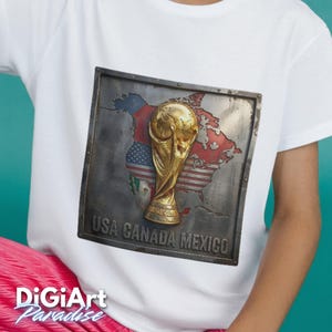 May include: White t-shirt featuring a metallic-style graphic of the FIFA World Cup trophy. The graphic includes a map of North America with the flags of the USA, Canada, and Mexico, and the text "USA CANADA MEXICO". The DigiArt Paradise logo is visible.