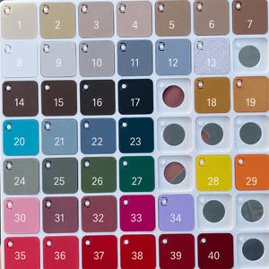May include: A white plastic grid display board featuring forty square colour swatches, each labelled with a number from 1 to 40. The swatches display a wide variety of solid colours, including shades of beige, grey, blue, green, yellow, pink, and red.