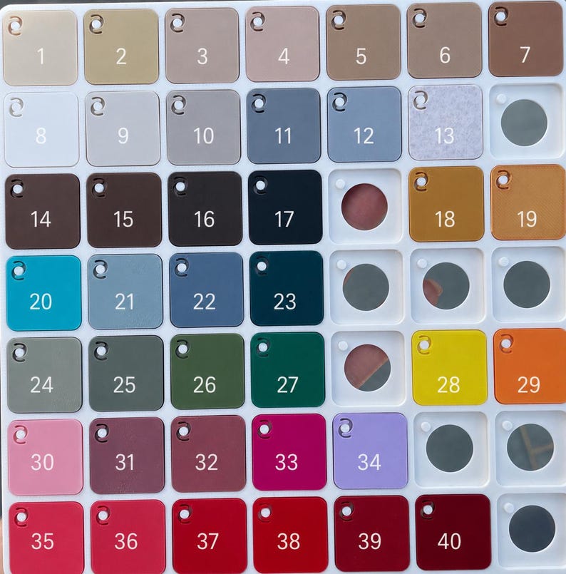 May include: A white plastic grid display board featuring forty square colour swatches, each labelled with a number from 1 to 40. The swatches display a wide variety of solid colours, including shades of beige, grey, blue, green, yellow, pink, and red.