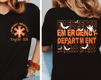Könnte beinhalten: Schwarzes V-Ausschnitt-T-Shirt mit einem orange-weißen Notfallmedizin-Logo (EMS) und dem Text "Taylor, RN" auf der Vorderseite. Auf der Rückseite des Shirts steht "EMERGENCY DEPARTMENT" mit Fledermäusen und einem Geist.
