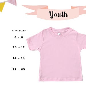 Puede incluir: Una camiseta rosa claro para ni&ntilde;os con mangas cortas. La palabra "Youth" se muestra en una pancarta encima de la camiseta. Una tabla de tallas muestra las tallas S, M, L y XL con los rangos de edad.