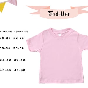 Puede incluir: Una camiseta rosa claro para ni&ntilde;os peque&ntilde;os. La imagen incluye una tabla de tallas con medidas en pulgadas y libras para las tallas 2T, 3T, 4T y 5T. La palabra "Toddler" est&aacute; escrita en una pancarta rosa.