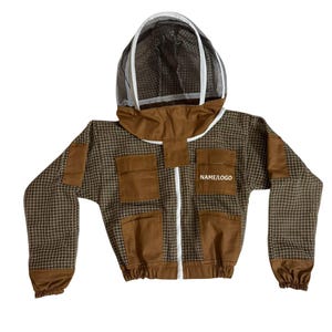 Könnte beinhalten: Eine braune und beige Imkerjacke mit Kapuze und Netzschleier. Die Jacke hat ein kariertes Muster, braune Taschen und einen weißen Reißverschluss. Der Text "NAME/LOGO" ist auf der Vorderseite aufgedruckt.