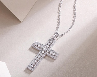 May include: A silver cross pendant necklace with a delicate chain. The cross is encrusted with numerous small, sparkling gemstones. The pendant is a religious symbol, suitable for everyday wear or special occasions.