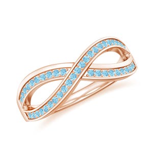 May include: Rose gold infinity ring with a row of light blue gemstones. The ring's design features a continuous loop, symbolizing eternity. The gemstones are evenly spaced along the ring's curves, creating a sparkling effect.