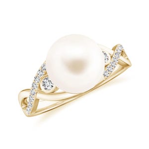 May include: A gold ring featuring a large, round white pearl as the centerpiece. The band has a twisted design, embellished with small, sparkling diamonds. The ring is set against a white background, highlighting its elegant design.