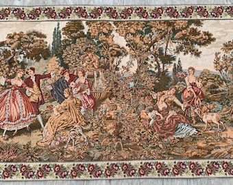 May include: A rectangular woven tapestry featuring a detailed garden scene with multiple figures in period clothing, trees, and a fountain. The border is decorated with a repeating pattern of small red roses and green leaves on a cream background.