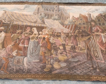 May include: A large tapestry depicting a medieval market scene with figures in period clothing. The artwork features tents, buildings, and a cobblestone street, with a detailed border in shades of brown and gold.