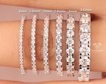 Puede incluir: Una mano muestra seis anillos de plata con piedras preciosas transparentes. Los anillos varían en ancho, etiquetados como 1 mm, 1,5 mm, 2 mm, 2,5 mm, 3 mm y 3,5 mm. Los anillos están engastados con múltiples piedras pequeñas y redondas.