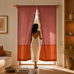 Puede incluir: Cortinas de lino color terracota con un panel inferior naranja-marrón en contraste. Las cortinas están abiertas, revelando una vista del exterior. La marca "NISHH" está impresa en la parte superior e inferior de la cortina.