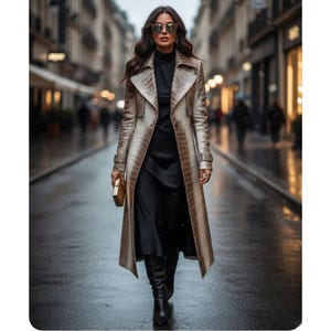 May include: A woman in a long, brown and beige faux crocodile skin trench coat, black dress, and black boots. She is holding a gold clutch and wearing sunglasses. The background is a city street.