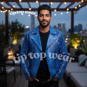 Op de afbeelding: Blauw leren jack met een slangenpatroon. De jas heeft een ritssluiting en een klassiek bikerjack-ontwerp. De tekst "tip top wear" wordt weergegeven in witte cursieve letters.
