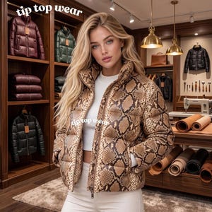 May include: A puffer jacket featuring a brown and black snakeskin print pattern with a high collar and a front zip closure. The text tip top wear is visible on the jacket and in the upper left corner of the image. The jacket is worn over a white top.