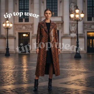 Op de afbeelding: Een vrouw draagt een lange, bruine jas met slangenprint, een zwarte jurk en zwarte laarzen. De jas heeft een klassieke revers en een lang, vloeiend ontwerp. De tekst "tip top wear" is zichtbaar.