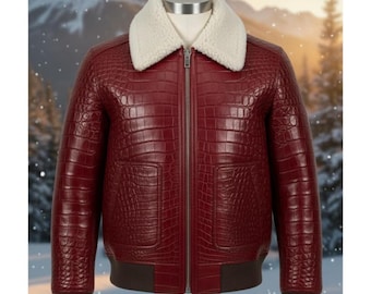 Puede incluir: Chaqueta de cuero burdeos con textura de cocodrilo. La chaqueta tiene un cuello de borrego blanco, una cremallera frontal y dos bolsillos delanteros. Los puños y el dobladillo son de punto acanalado marrón oscuro.
