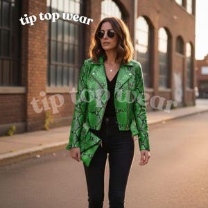 May include: A green snakeskin-patterned jacket with a zip and a matching clutch. The jacket is worn over a black top and black jeans. The text "tip top wear" is visible in the image.