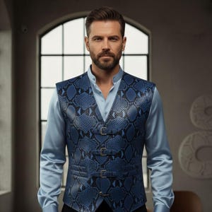 May include: A blue snakeskin-patterned vest with three buckle closures. The vest is worn over a light blue collared shirt. The image is a medium shot of a person.