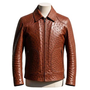 May include: A brown leather jacket with a textured surface and a full-zip closure. The jacket features a collared neckline, two front pockets, and a tailored fit. The jacket is displayed on a mannequin.