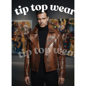 Könnte beinhalten: Braune Lederjacke mit Schlangenmuster, mit Reverskragen und doppelreihigem Design. Die Jacke wird über einem schwarzen Rollkragenpullover getragen. Der Text "tip top wear" wird in Weiß, in gebogener Form über und unter dem Motiv angezeigt.
