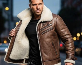 May include: Brown leather jacket with a cream-colored shearling lining and collar. The jacket features multiple zippered pockets, a buckled wrist cuff, and a classic aviator style. The jacket is worn open, revealing the cream-colored interior.