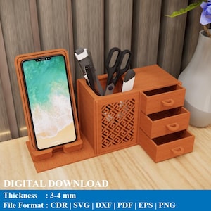 May include: A wooden desk organizer with a phone holder, pen and scissor storage, and three small drawers. The organizer is made of light brown wood and has a decorative pattern on the side. The text "DIGITAL DOWNLOAD" is visible.