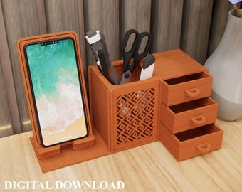 Puede incluir: Un organizador de escritorio de madera con un soporte para teléfono, almacenamiento de bolígrafos y tijeras y tres cajones pequeños. El organizador es de madera marrón claro y tiene un patrón decorativo en el lateral. El texto "DIGITAL DOWNLOAD" es visible.