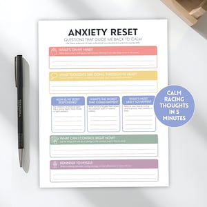 May include: A white Anxiety Reset worksheet with colorful sections for writing, featuring prompts like What's On My Mind and What Can I Control Right Now. A circular blue badge reads Calm Racing Thoughts In 5 Minutes. A black pen lies to the left.