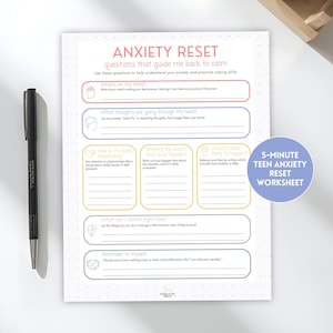 May include: A white worksheet titled "ANXIETY RESET" with prompts to manage anxiety. A black pen rests on the left. A blue circle on the right reads "5-MINUTE TEEN ANXIETY RESET WORKSHEET".