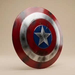 May include: A circular shield in red, white, and blue, featuring a silver star at its centre. The design includes concentric rings of colour and a distressed, battle-worn finish. A classic superhero accessory.