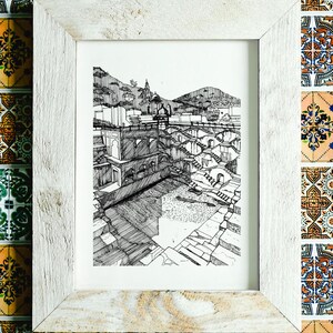 May include: A framed black and white pen and ink drawing of a stepwell. The artwork is in a white wooden frame. The background is a colorful tile mosaic.