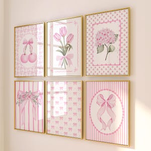 Könnte beinhalten: Sechs gerahmte Kunstdrucke mit goldenen Rahmen. Die Drucke zeigen Aquarellillustrationen von rosa Schleifen, Kirschen, Tulpen und einer Hortensie. Die Hintergründe umfassen rosa Muster und Streifen, was eine feminine Ästhetik schafft.