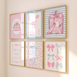 May include: A set of six framed wall art prints featuring pink and blue color palettes. Designs include a stack of books, a playing card with a bow, a perfume bottle with a large bow, the text BRAVE GIRLS CLUB, floral patterns, and various bows.