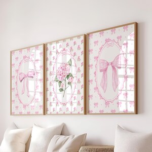Peut inclure: Trois œuvres d'art encadrées avec une finition en bois clair. Chacune présente un motif aquarelle d'un nœud rose ou d'une fleur d'hortensia rose dans un cadre ovale. Le fond est un motif blanc avec de petits nœuds et fleurs roses.