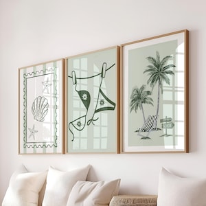 May include: Three framed art prints with a beach theme. The prints feature a seashell and starfish, a bikini hanging on a washing line, and palm trees with a beach chair. The colour palette is green and white.