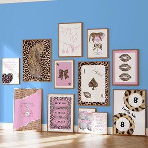 May include: A collection of framed wall art with a leopard print theme. The art includes images of a leopard, playing cards, lips, a telephone, and text that reads "Lucky You", "Lucky Me", and "Lucky Us". The color palette includes pink, brown, and white.