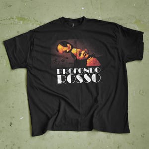 May include: Black t-shirt featuring a graphic from the film "Profondo Rosso." The design includes a portrait of two faces in shades of red and brown, with the film's title in white block letters.