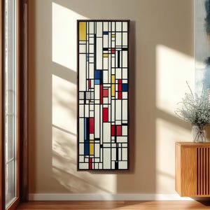 Puede incluir: Arte mural geométrico abstracto en formato rectangular vertical. La obra presenta un fondo blanco con una cuadrícula de líneas negras y bloques rectangulares de colores en rojo, azul, amarillo y gris. La obra está enmarcada en un marco de madera marrón oscuro.